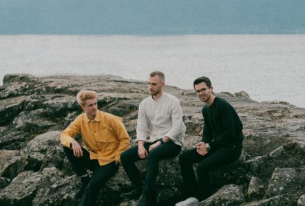 Les trois musiciens sur des rôchers au bord du lac