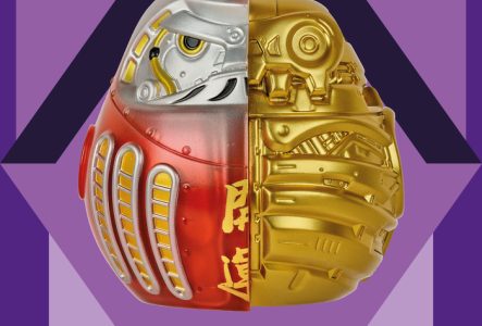 Affiche de l'exposition qui présente un daruma dans un losange. Le daruma est une figurine japonaise qui permet de faire des voeux. Le fond est violet foncé et le losange et mauve, violet clair.