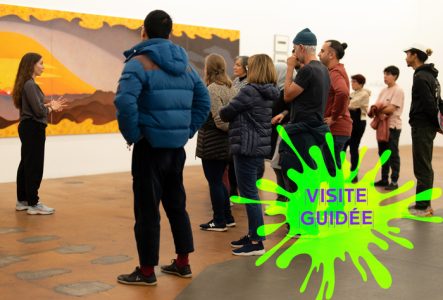 une médiatrice présente des œuvres à un groupe de visiteurs