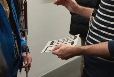 des personnes aveugles découvrant une exposition grâce à des supports tactiles