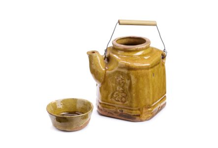 Théière japonaise en céramique jaune foncé avec sa tasse.