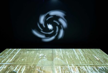 Une des oeuvres de l'exposition. Fond noir avec projection d'étoiles.