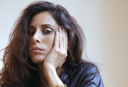 Portrait de Yasmine Hamdan qui appuie son visage sur sa main gauche