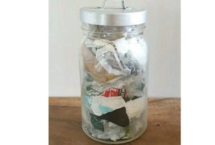 Un pot en verre plein de déchets ménagers